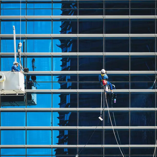 Laveurs de vitres sur la façade vitrée d'un immeuble de bureaux